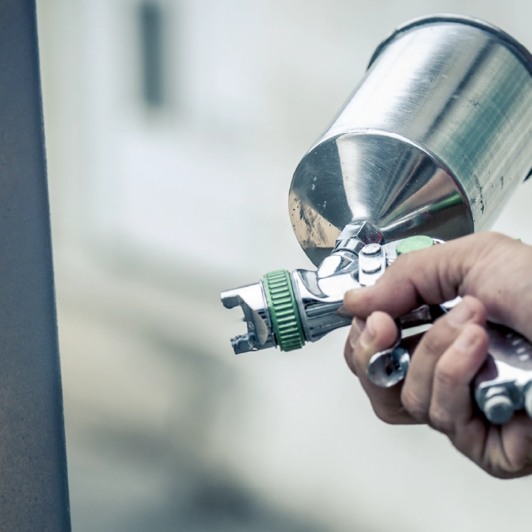 Pistolet lakierniczy w ręce